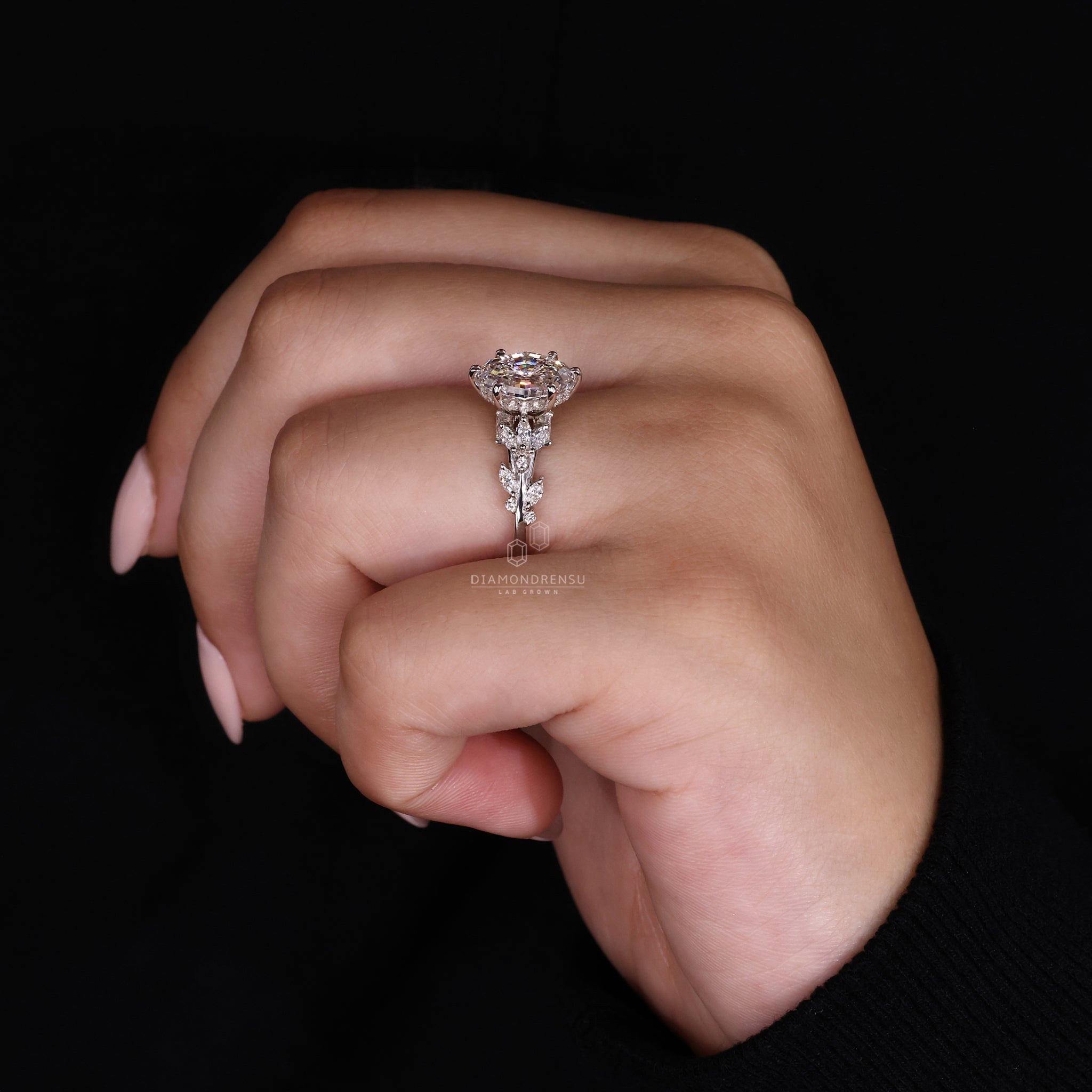 Model showing off a diamondrensu nature inspired ring with a step cut oval diamond and natural design elements.