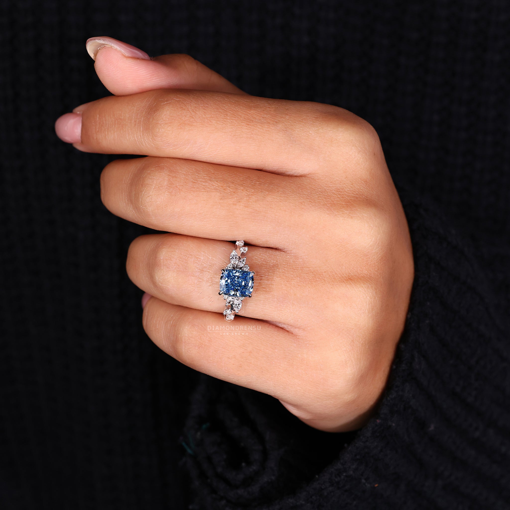 Diamondrensu UK ring with cushion cut centre and unique blue tone.

