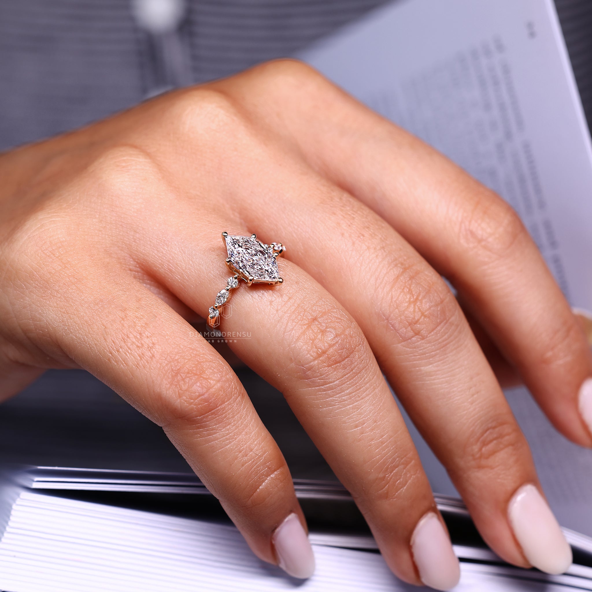 Marquise and round side stone design in yellow gold.
