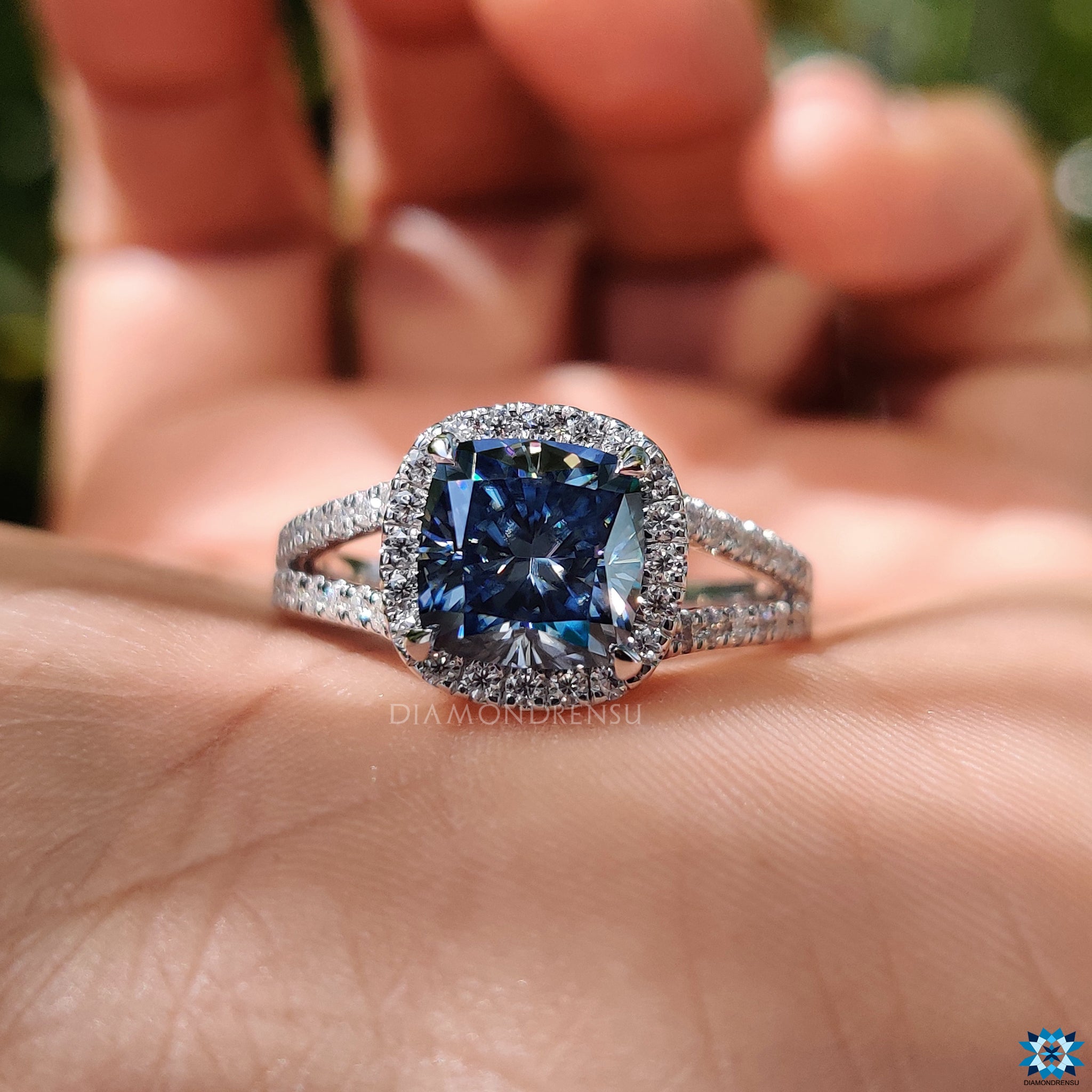 Buy engagement ring with halo-set royal blue cushion moissanite and round cut split shank.
