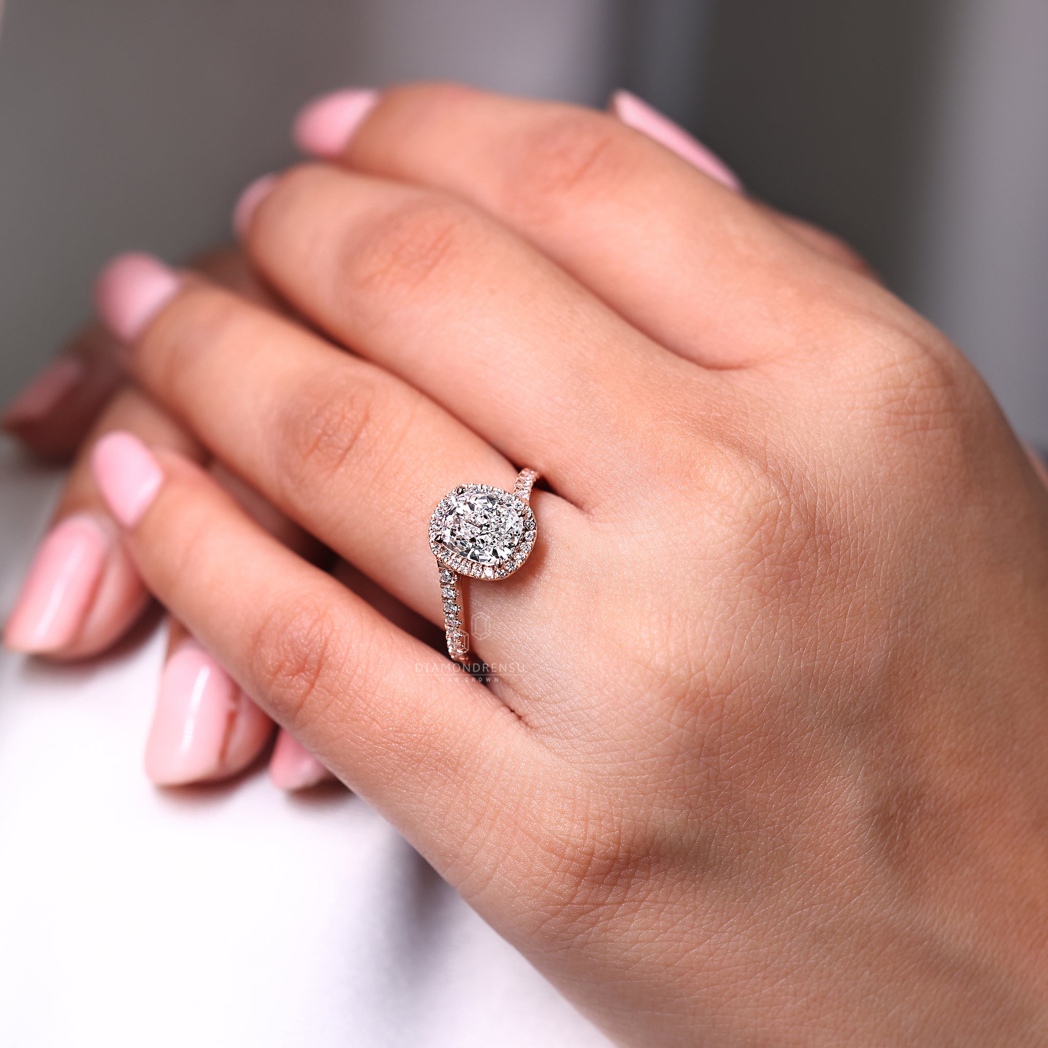 Halo style ring with cushion center in rose gold.
