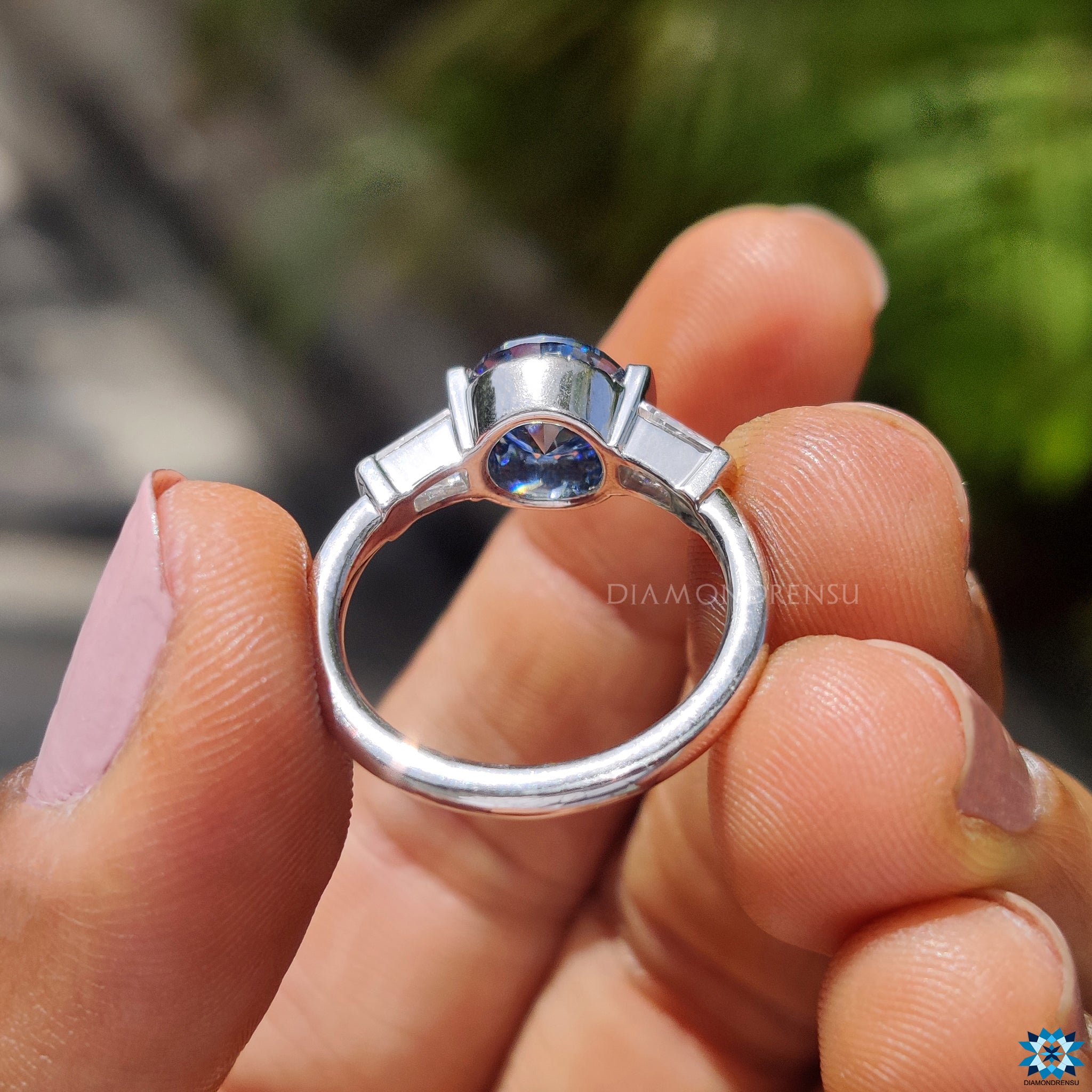 Three stone ring with tapered baguette cut moissanites on each side.
