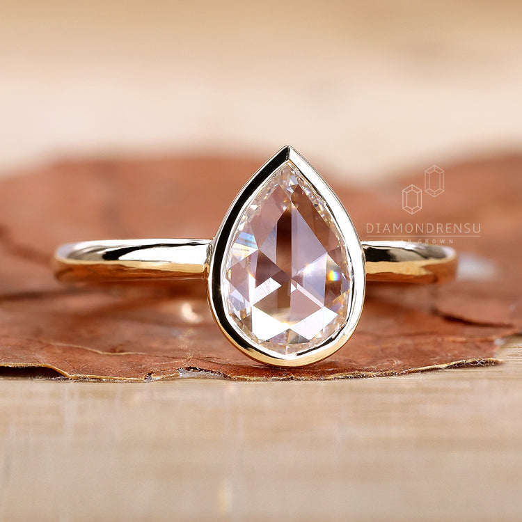 Pear diamond ring in yellow gold bezel setting

