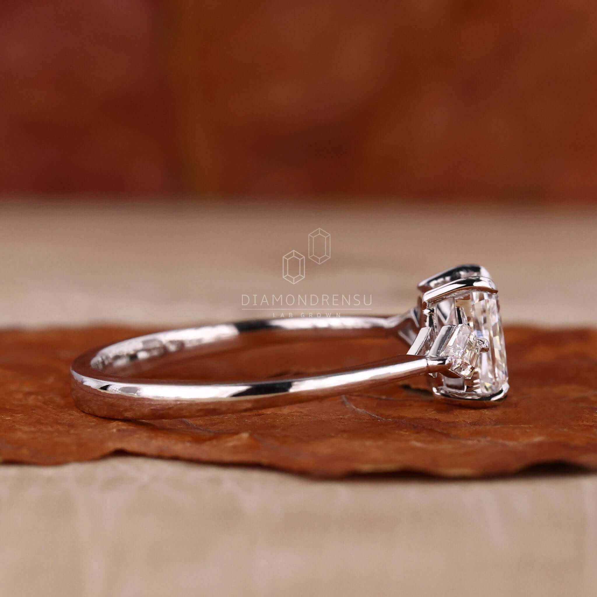 Radiant cut ring designed as a three stone diamond ring in white gold.
