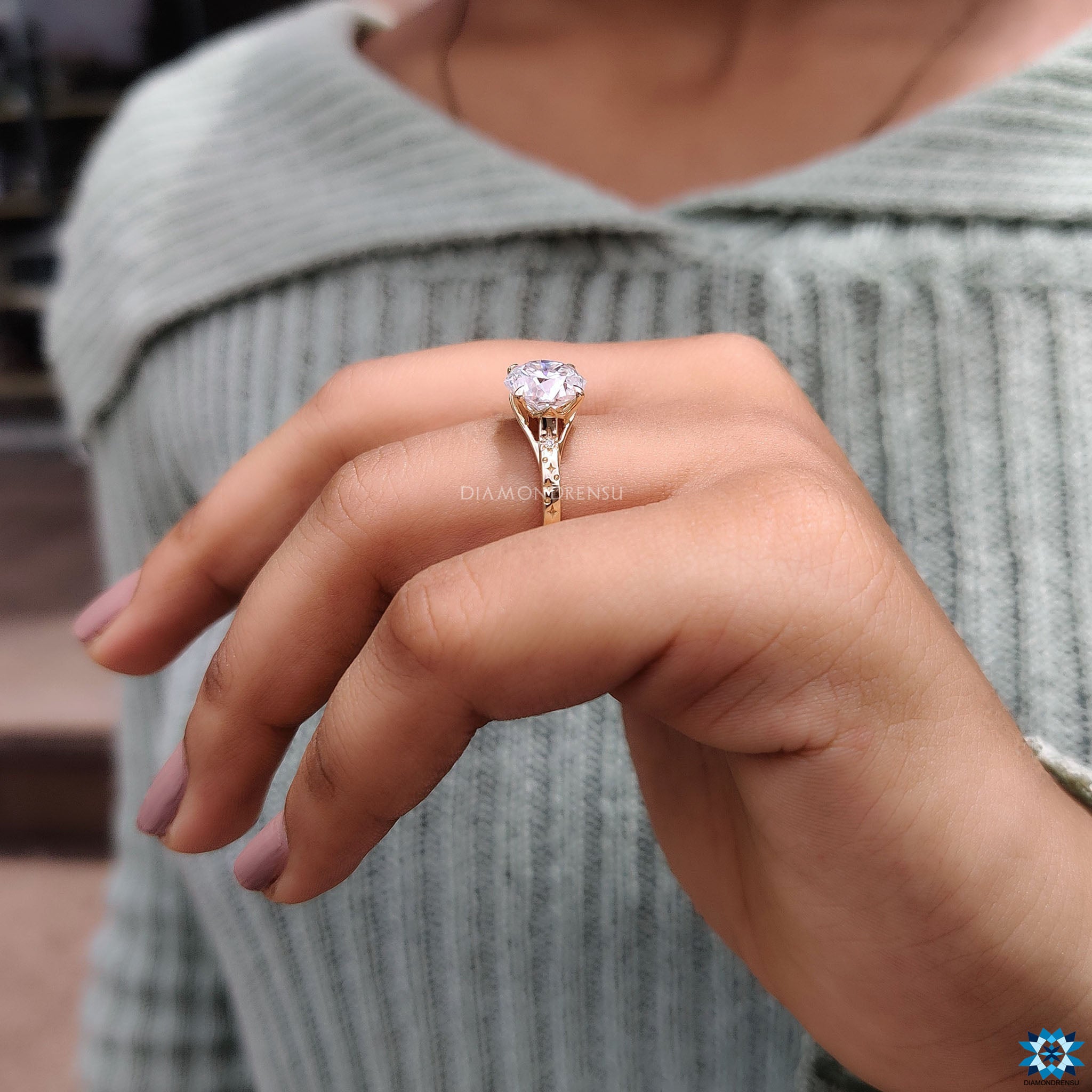 Handmade yellow gold engagement ring with round cut side stones.
