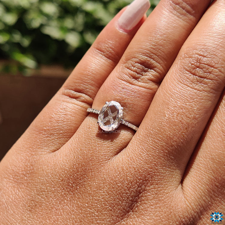 UK engagement ring showcasing oval rose cut stone and round pave band.
