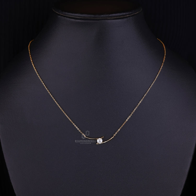 Round diamond pendant in yellow gold with bypass styling.
