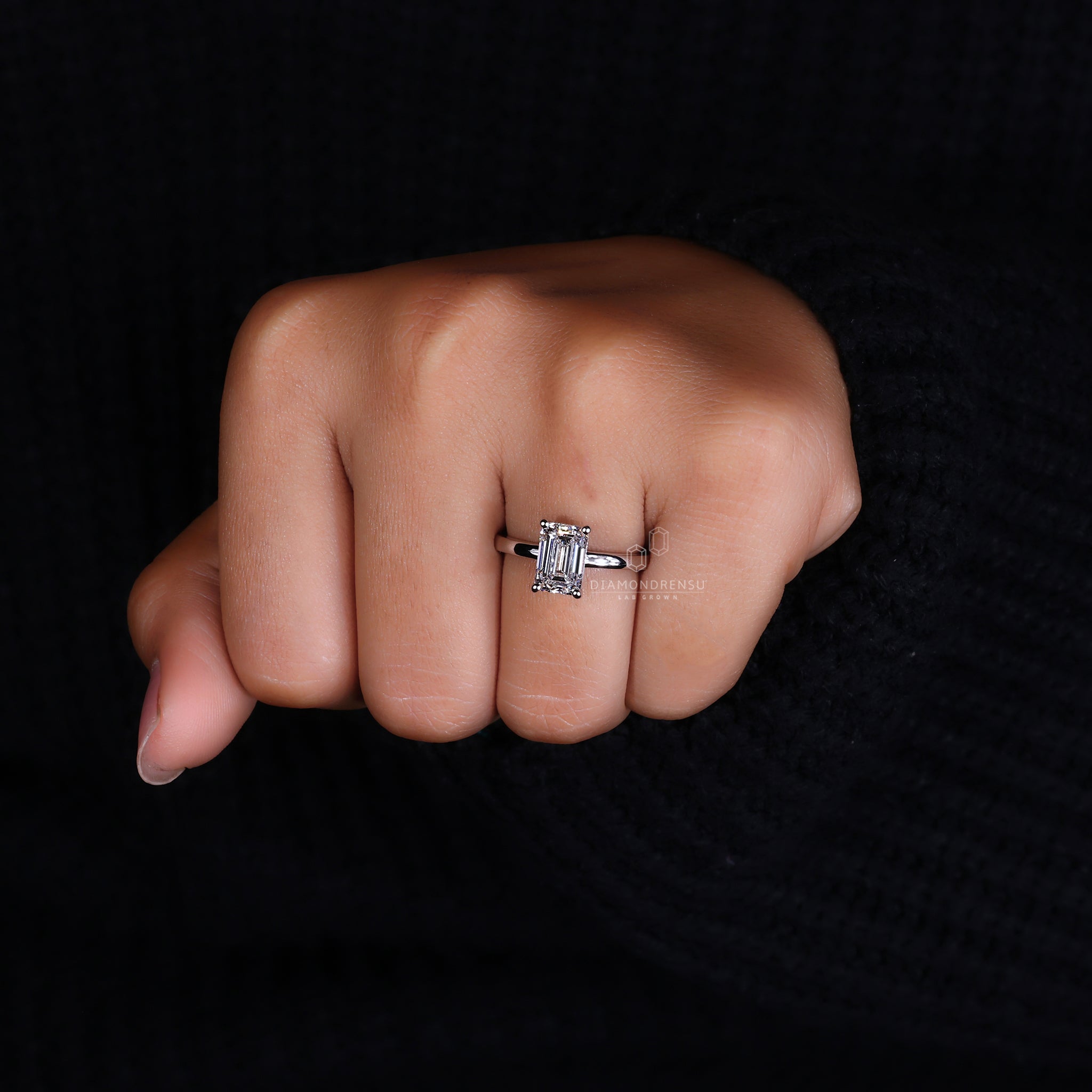 Hidden halo engagement ring featuring an emerald cut stone.

