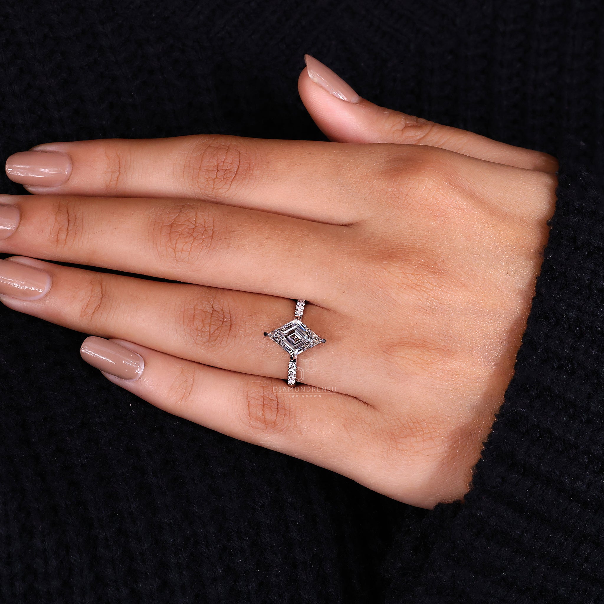 White gold ring with a pavé setting and lozenge cut diamond.
