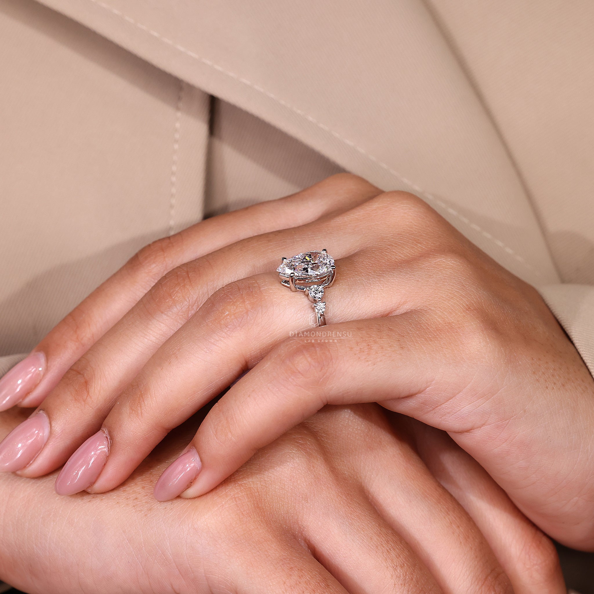Diamondrensu UK engagement ring with round side stones and handmade finish.
