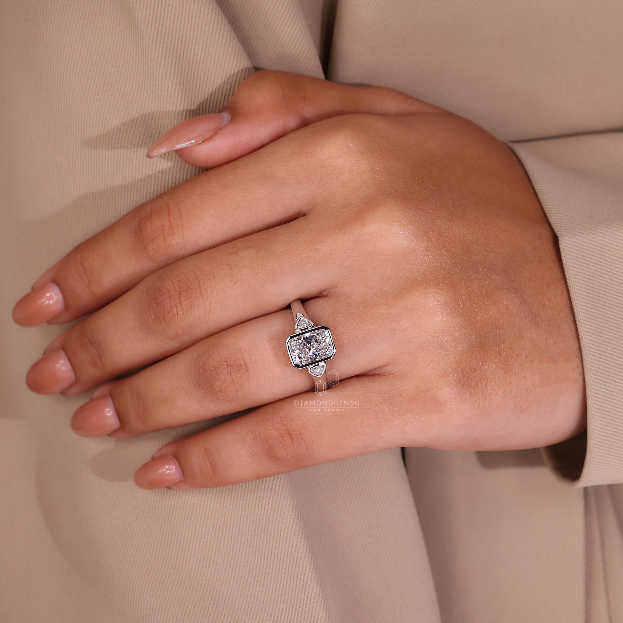 This UK engagement ring includes a bezel set and radiant cut diamond.
