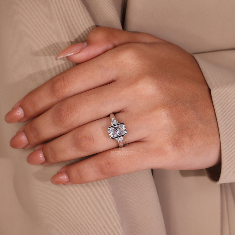 This UK engagement ring includes a bezel set and radiant cut diamond.
