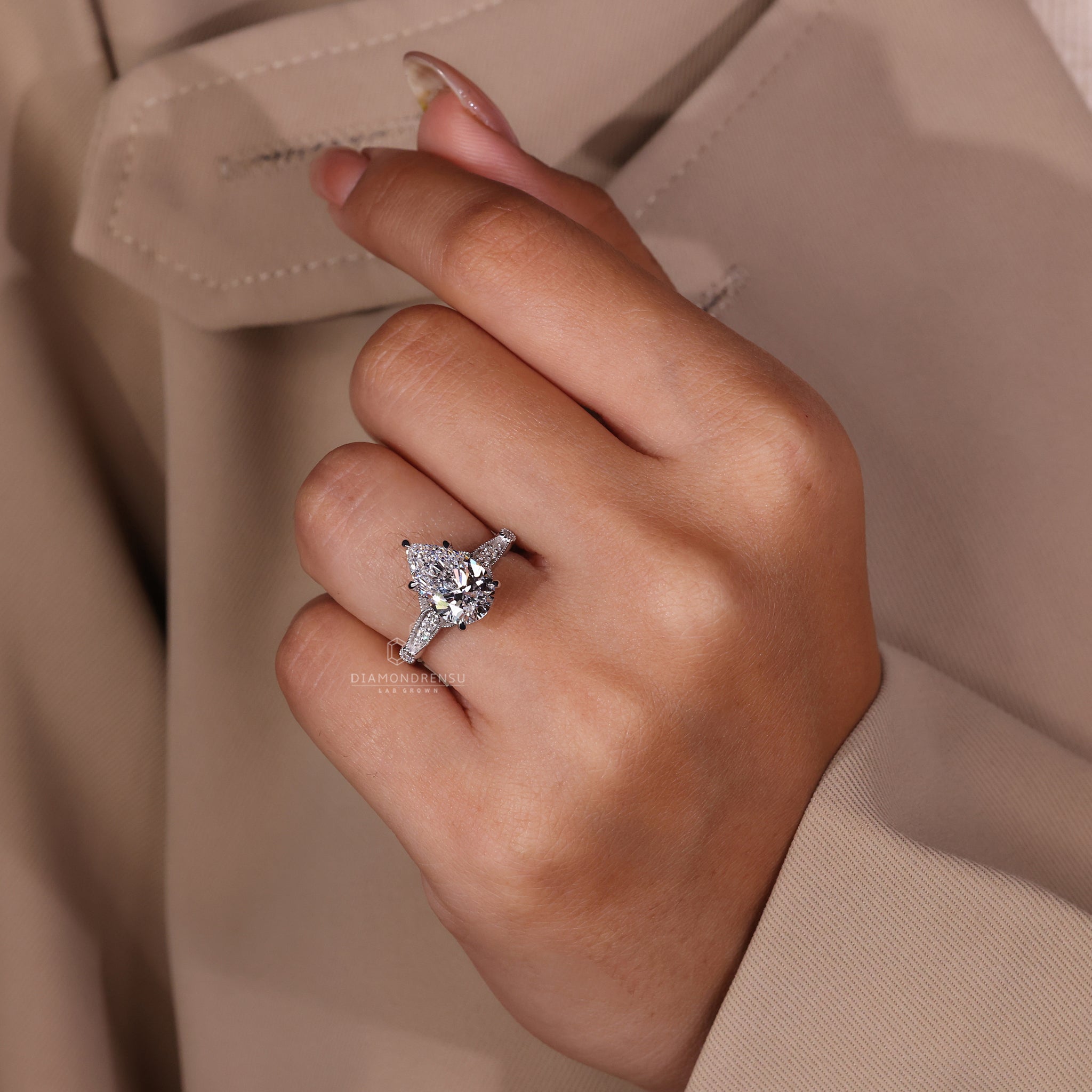 Claw prongs setting on pear diamond ring in white gold finish.

