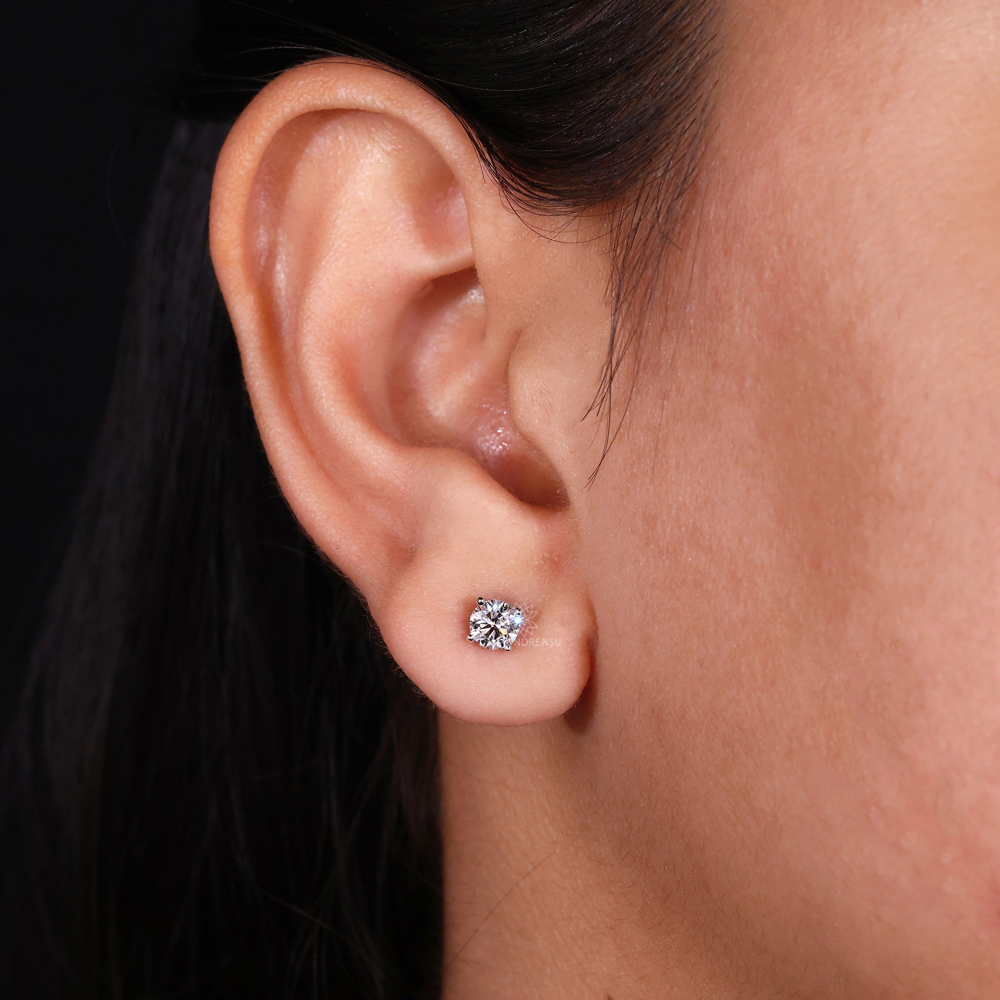 Prong setting earrings designed as classic round diamond studs.