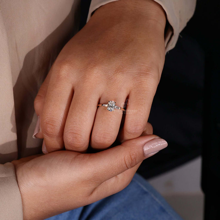 Three stone diamond ring in gold with an oval shaped diamond ring for timeless elegance.
