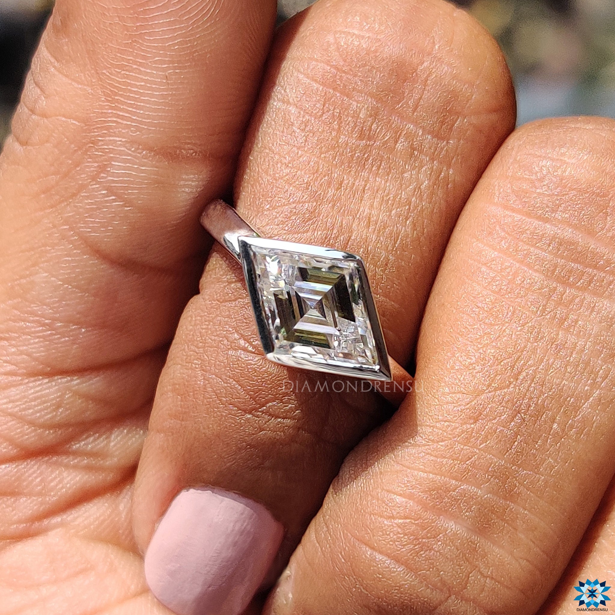 Custom moissanite engagement ring with bezel setting.
