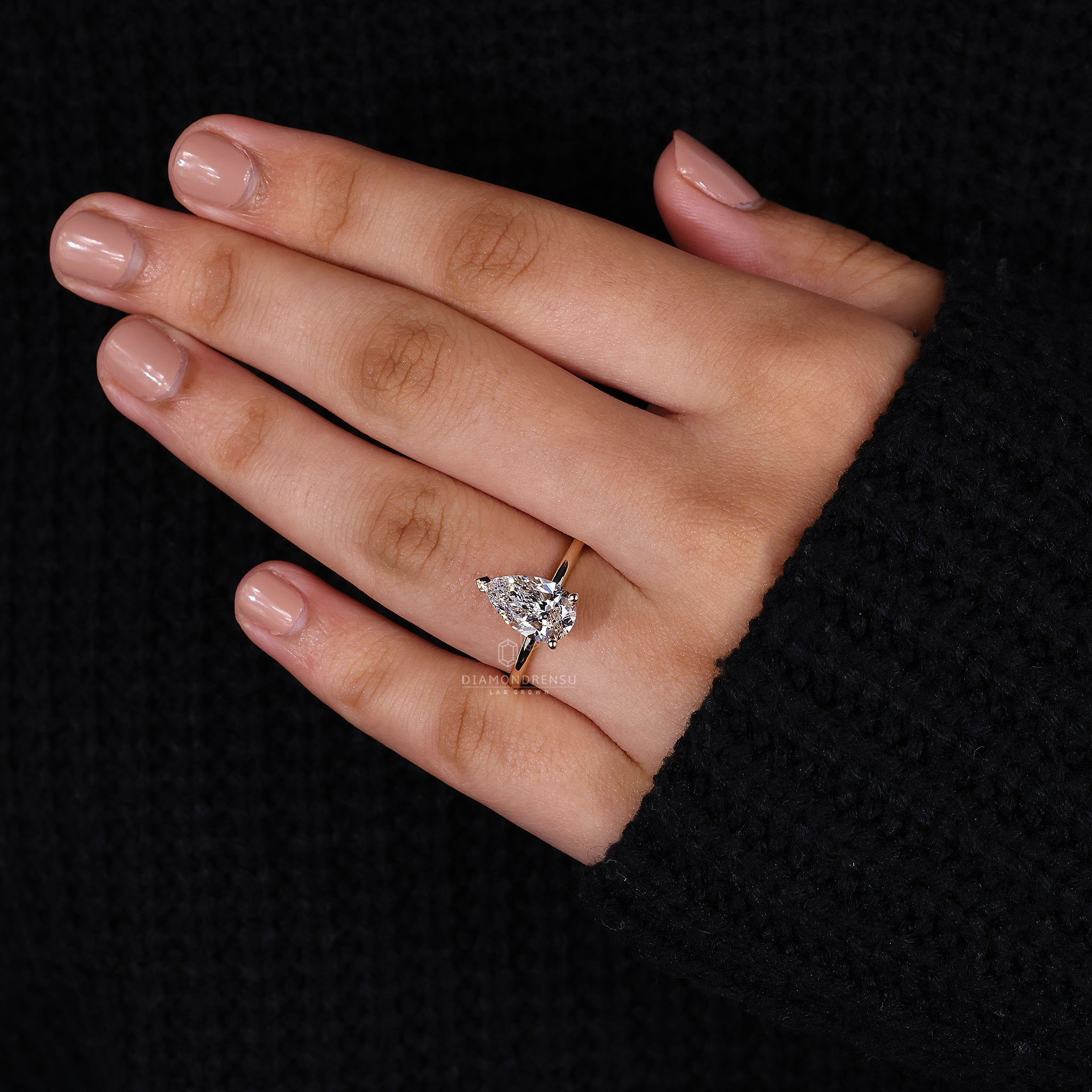 Custom engagement ring with pear cut solitaire design.
