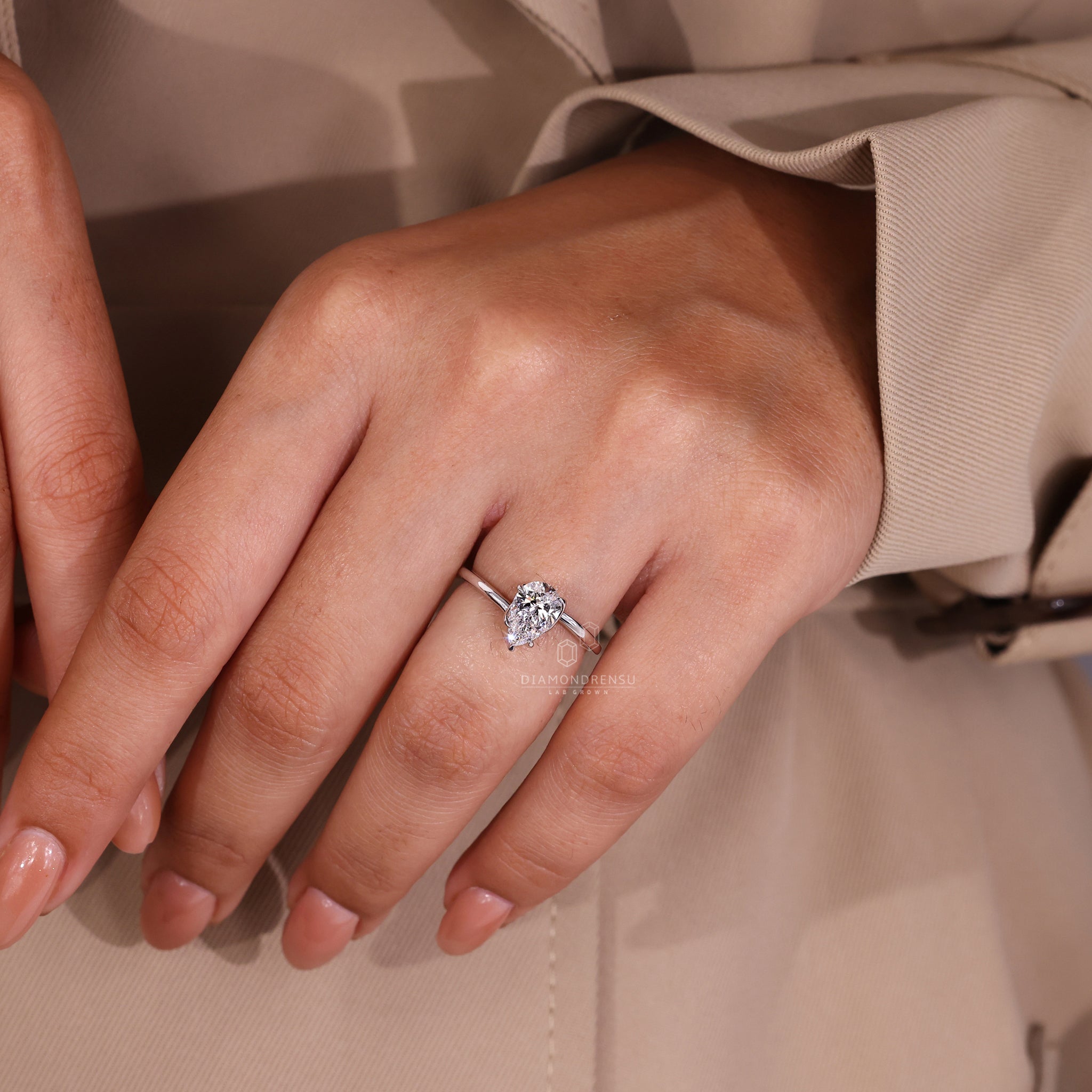 Twisted prong ring design with pear cut diamond centre.
