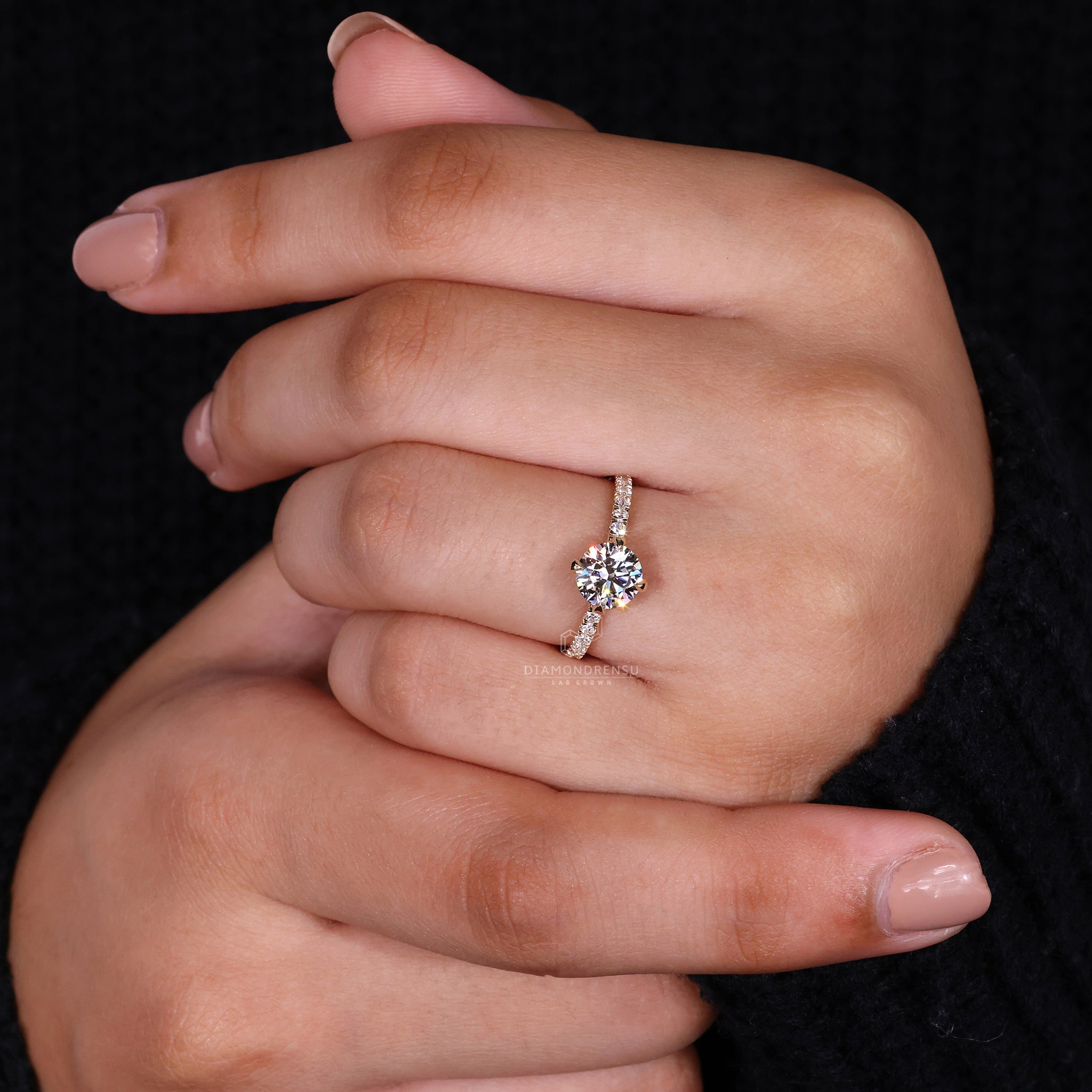 Lab diamond ring with prong set design and pave set band accents.
