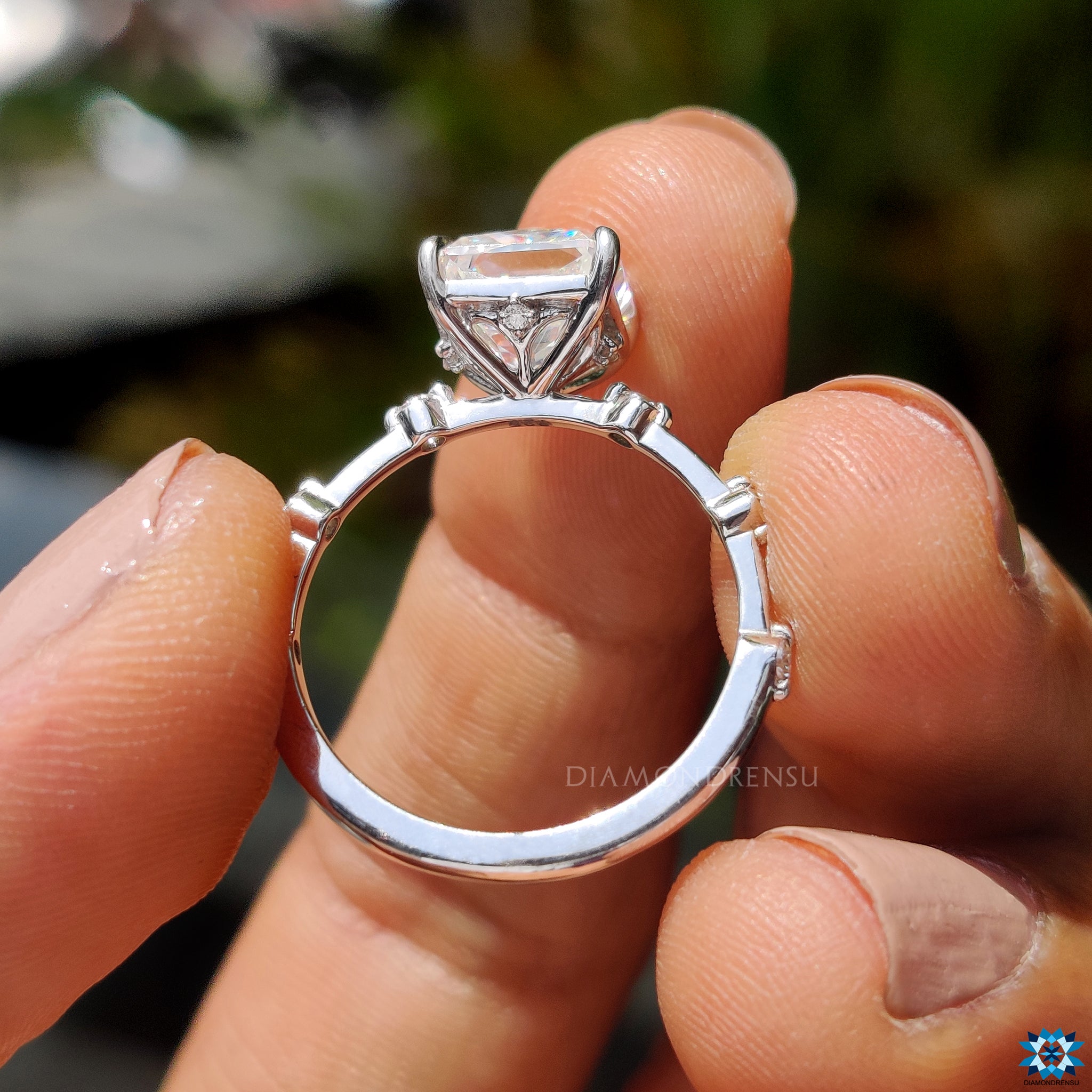 Custom engagement ring featuring radiant Rensu moissanite and round pave accents.
