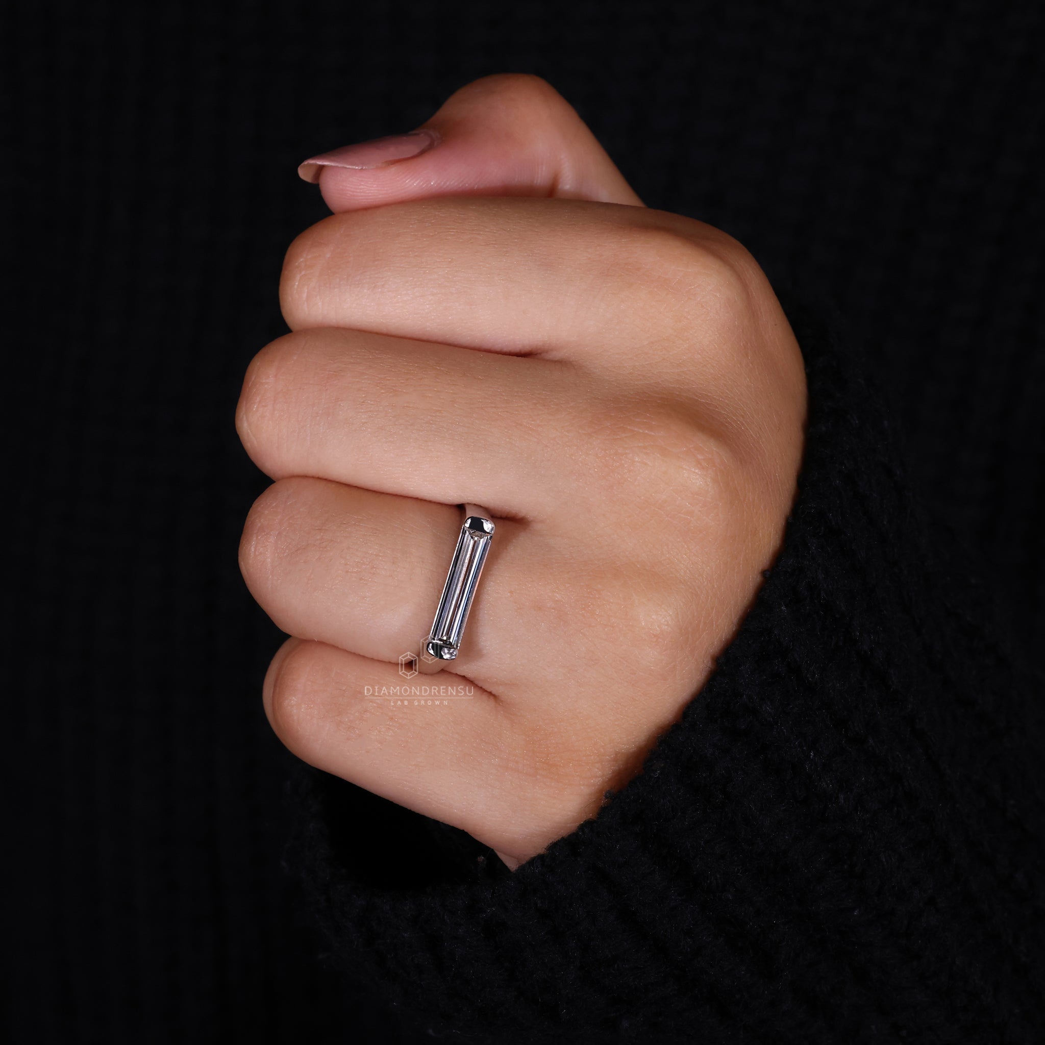 Close-up of bezel setting baguette diamond ring on model’s hand