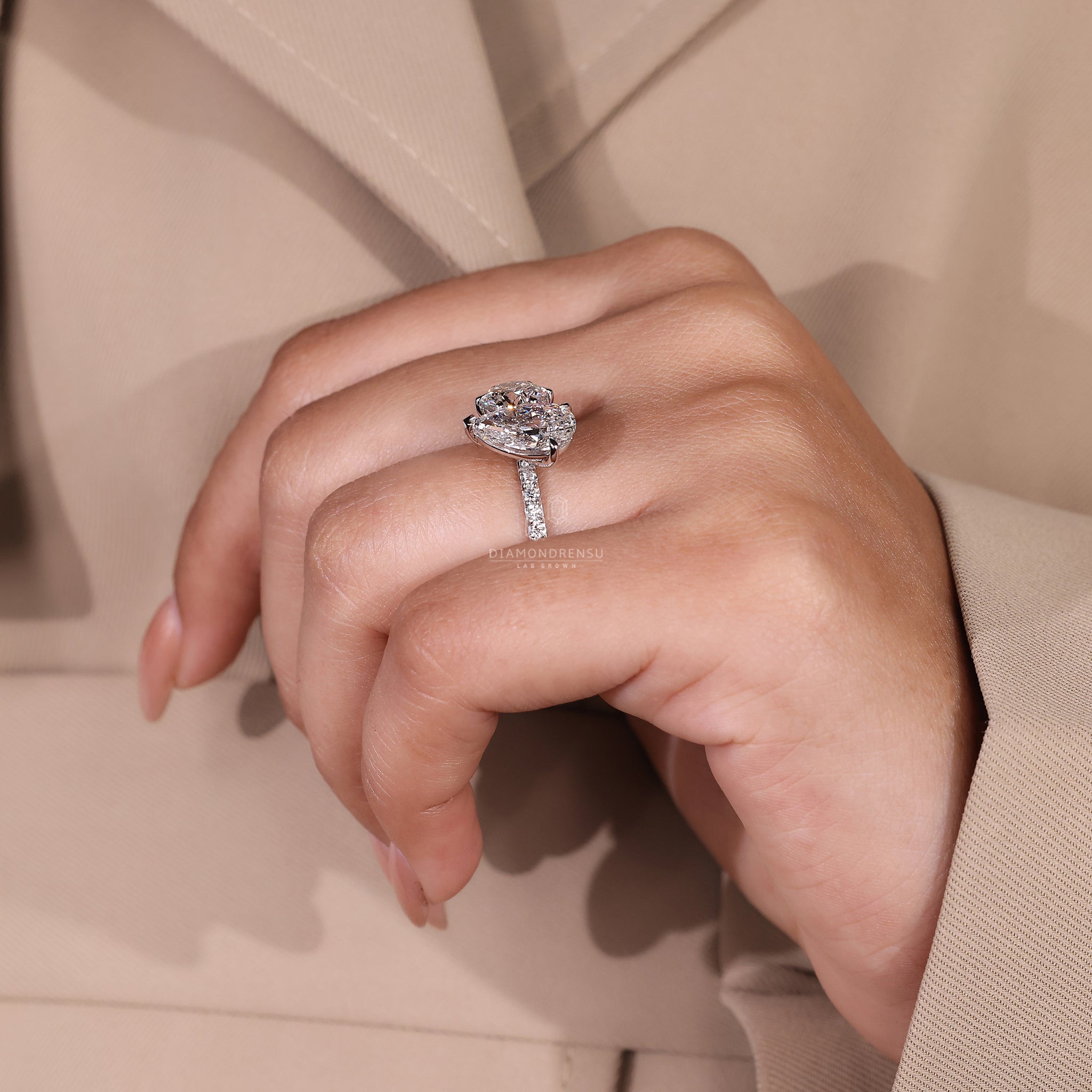 White gold engagement ring featuring pear and round diamond cluster.
