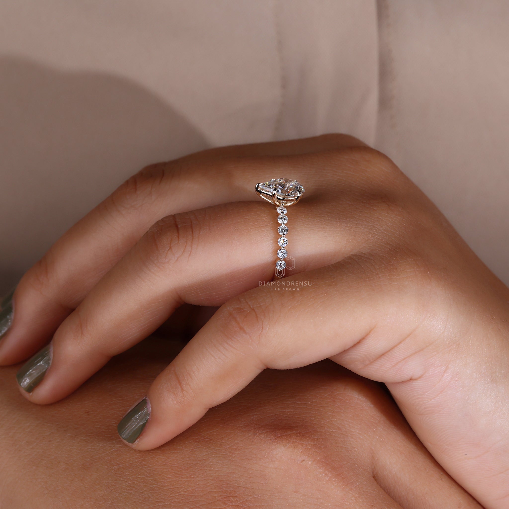 Model displaying a non-traditional engagement ring with a spear cut diamond and yellow gold band.