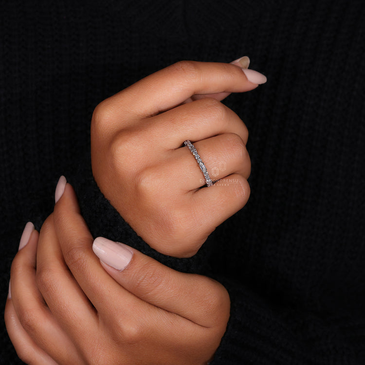 Elegant half eternity wedding band with emerald and round diamonds.
