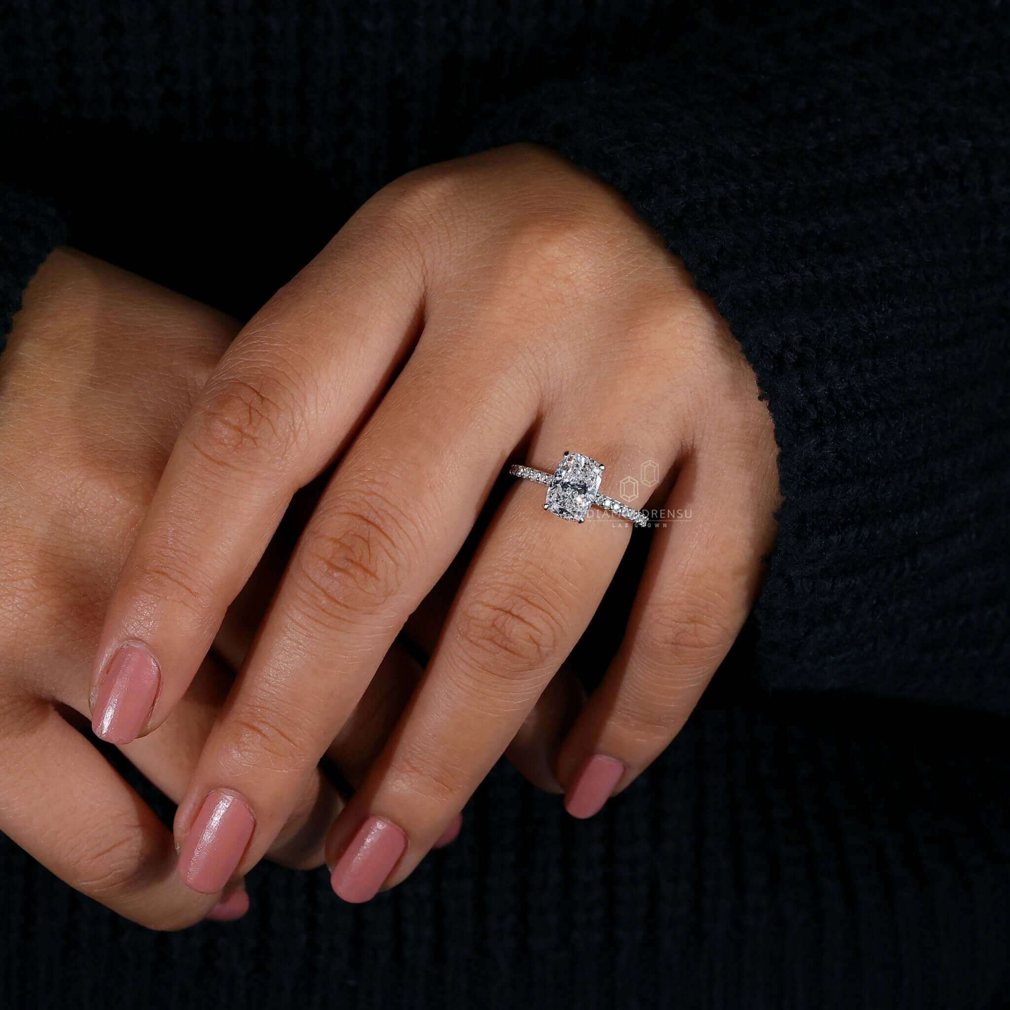 Cathedral setting engagement ring with a cushion cut diamond and pave ring diamond accents.