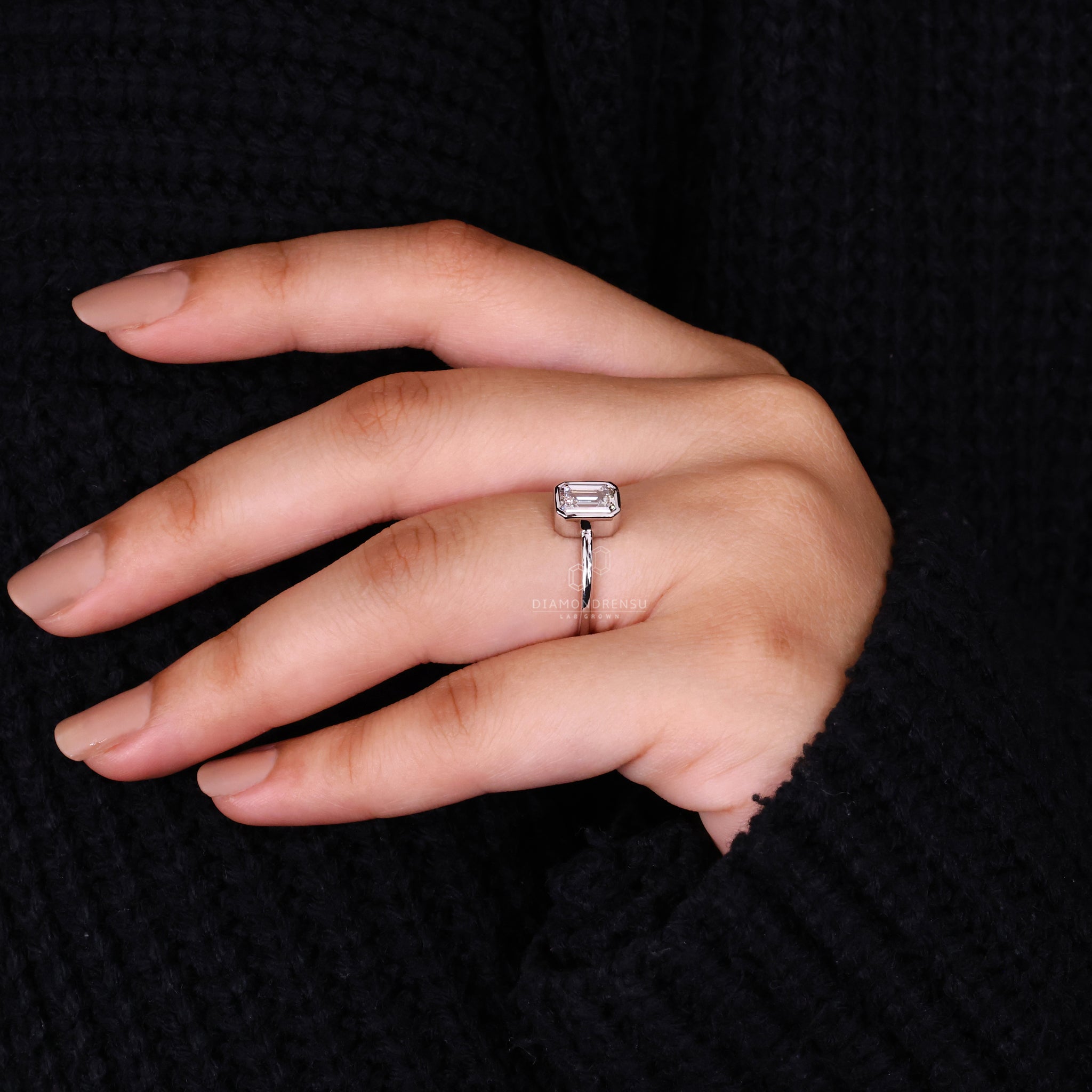 Custom engagement ring featuring an emerald cut diamond.
