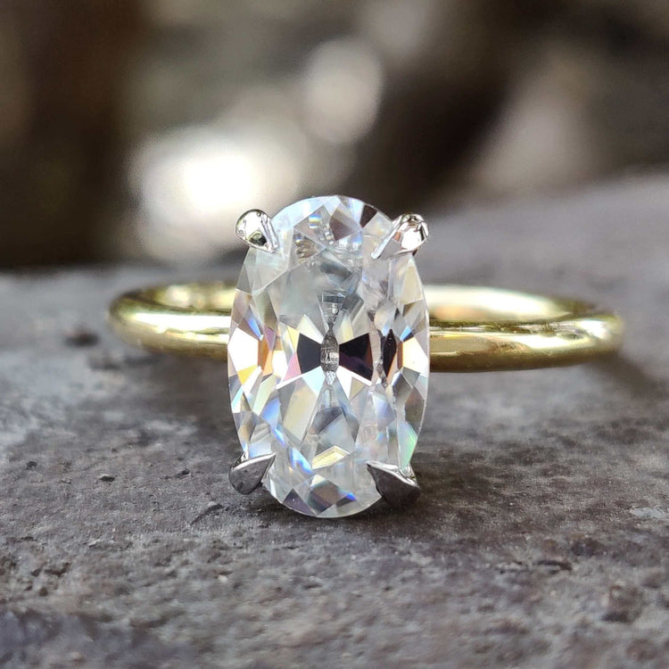Moval cut moissanite solitaire ring in yellow gold.
