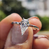 Moissanite solitaire ring featuring a spear cut stone in a prong setting.
