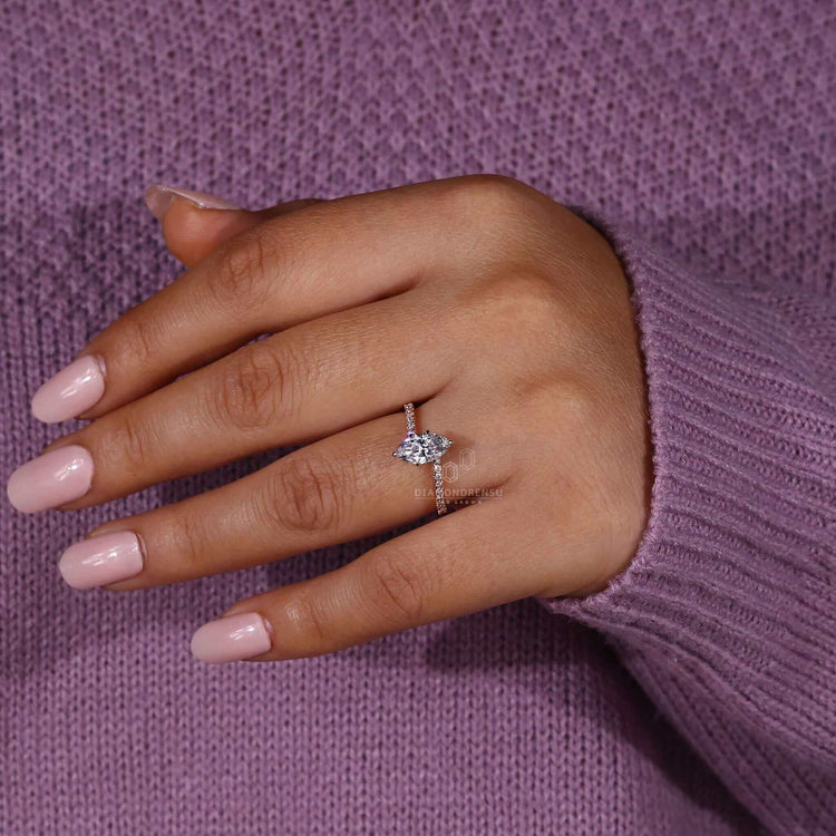 Six prong diamond ring featuring a marquise cut diamond and a pave ring setting for a flawless finish.
