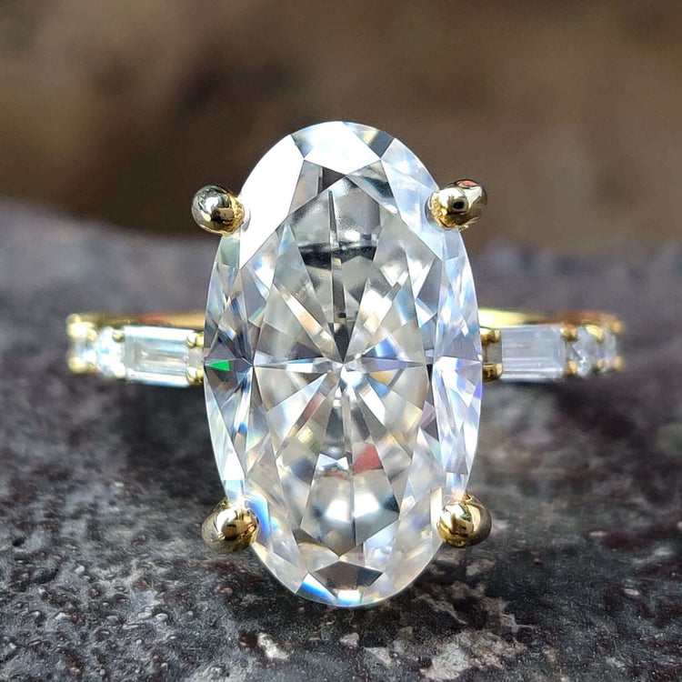 Moval cut moissanite ring with pave setting in yellow gold.
