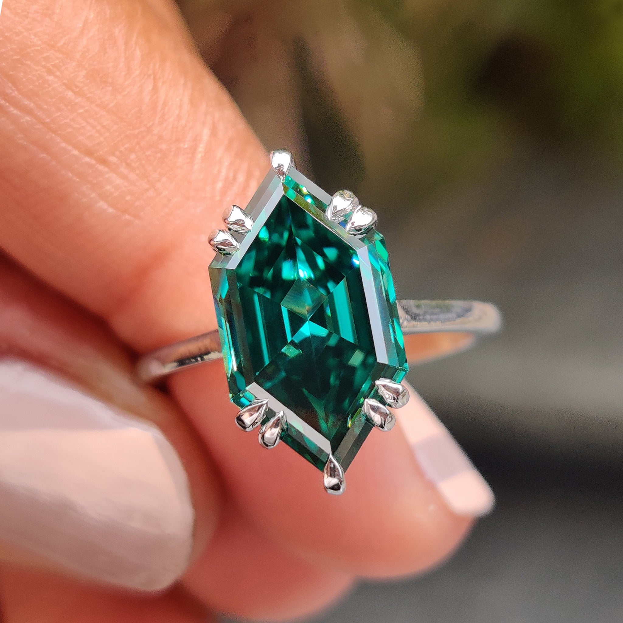 White gold moissanite ring featuring a Dutch marquise green centre stone.
