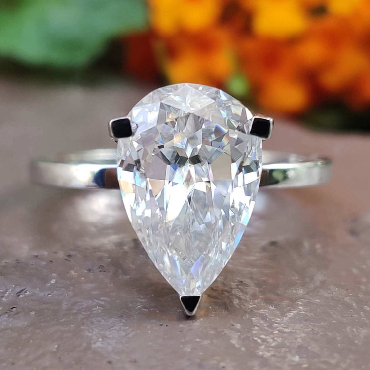 Pear cut moissanite solitaire engagement ring in white gold.
