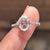 Oval rose cut moissanite engagement ring with round hidden halo setting.
