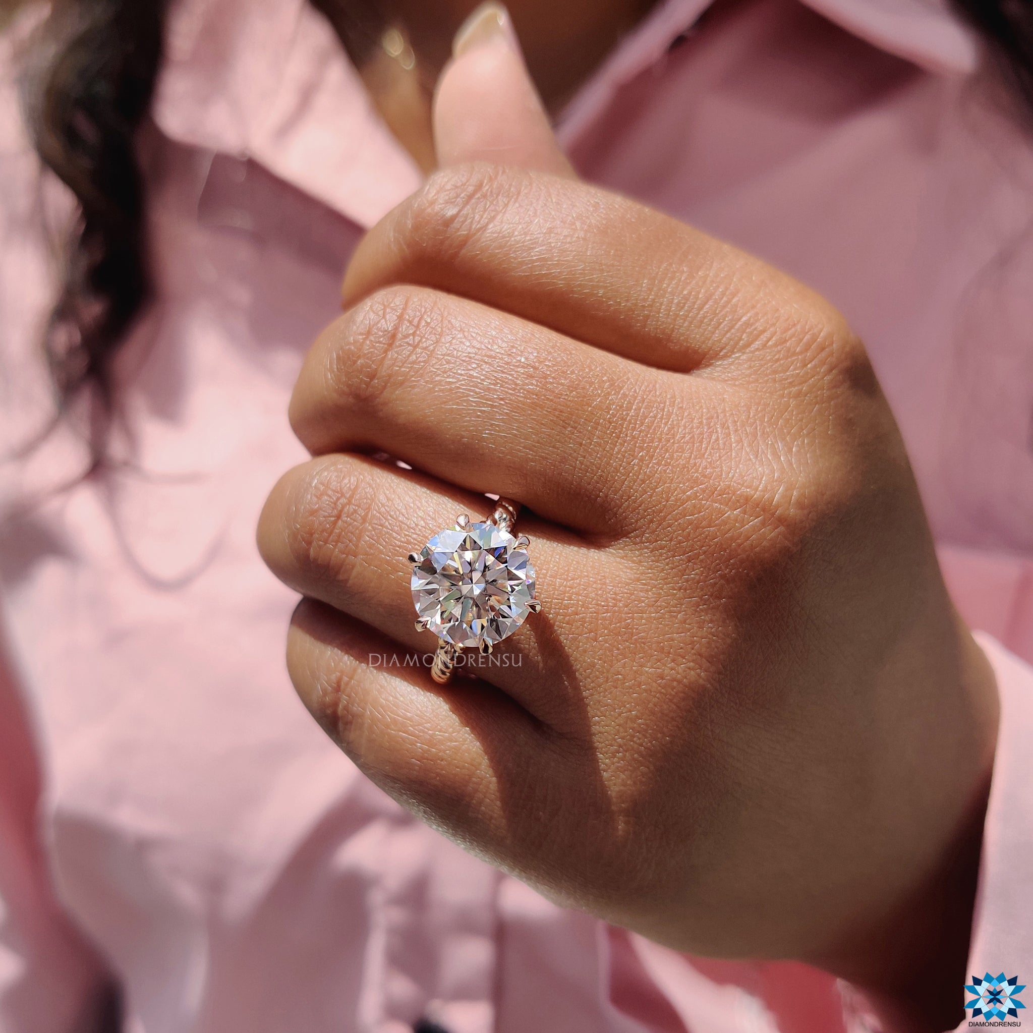 Twisted band design highlighting round cut moissanite in rose gold.
