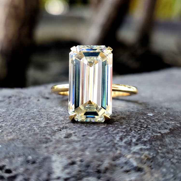 Emerald solitaire ring set in yellow gold with 4 prong claw setting.
