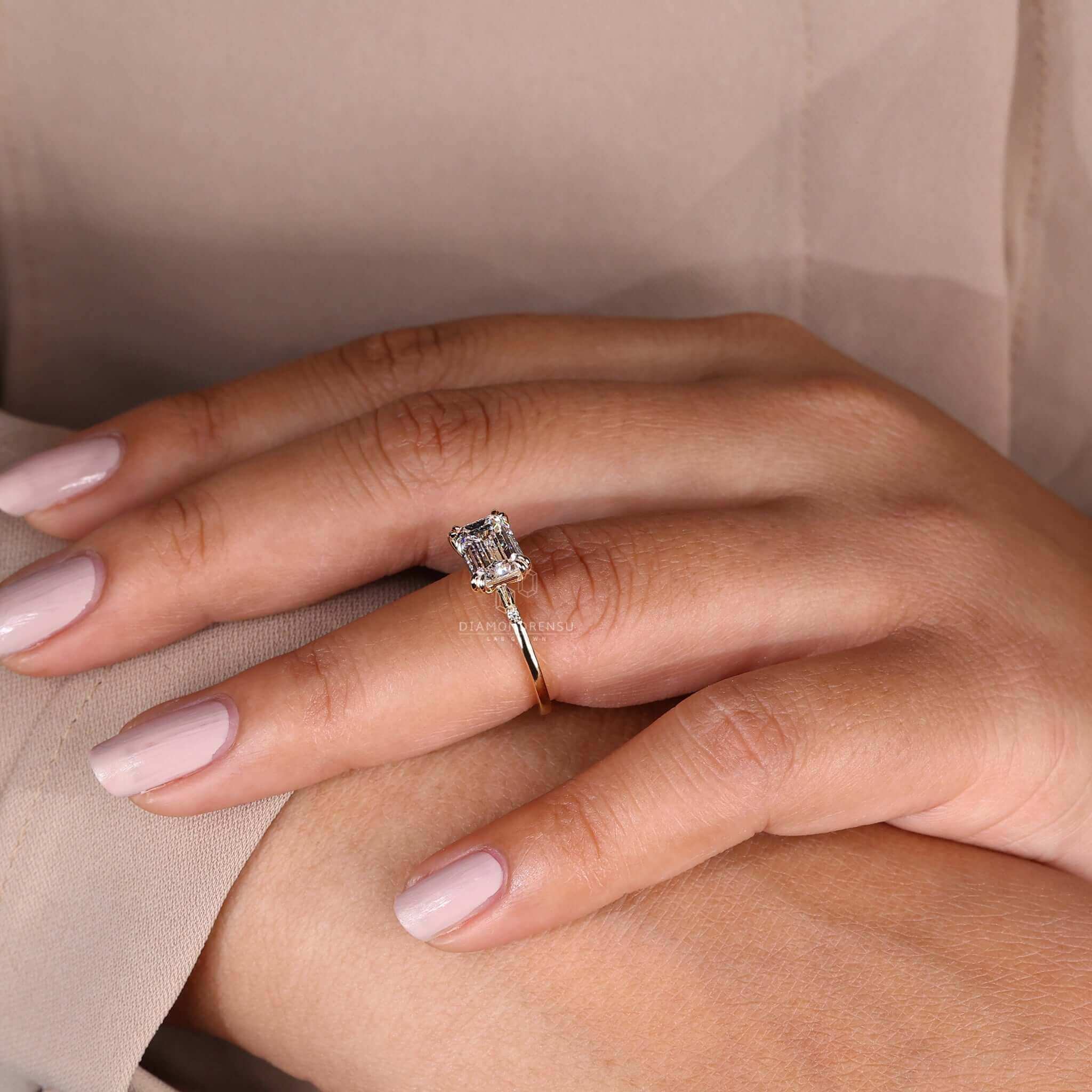 East west engagement ring showcasing a striking emerald cut diamond.