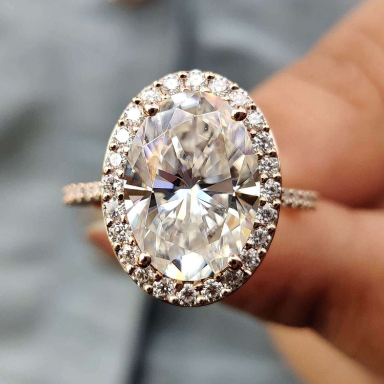 Oval hidden halo engagement ring with oval cut moissanite.
