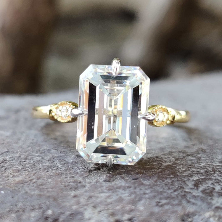 Emerald cut moissanite engagement ring in yellow gold.

