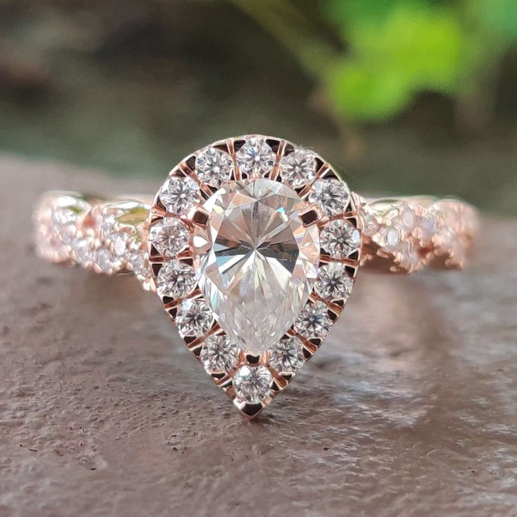 Pear cut moissanite halo ring in rose gold.
