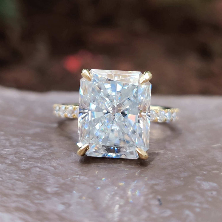Hidden halo radiant cut moissanite engagement ring in yellow gold.
