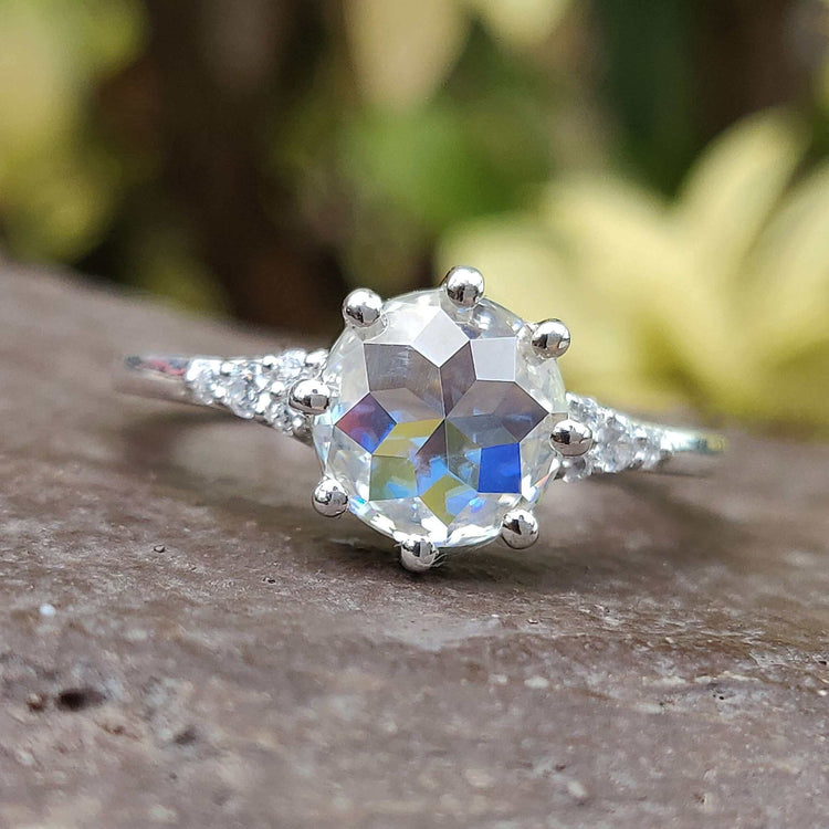 White gold Moissanite ring featuring round rose cut stone in a prong setting.
