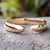 Elegant open wedding band in yellow gold with modern design.