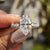 Dutch marquise ring with round cut hidden halo in white gold.
