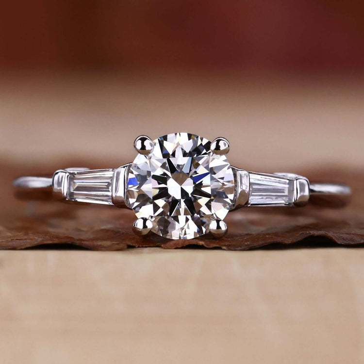 3 Stone Diamond Ring featuring tapered baguette accents and a stunning round brilliant cut for a timeless engagement design.
