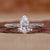 Close-up of a pear shaped diamond ring featuring twisted diamond pave