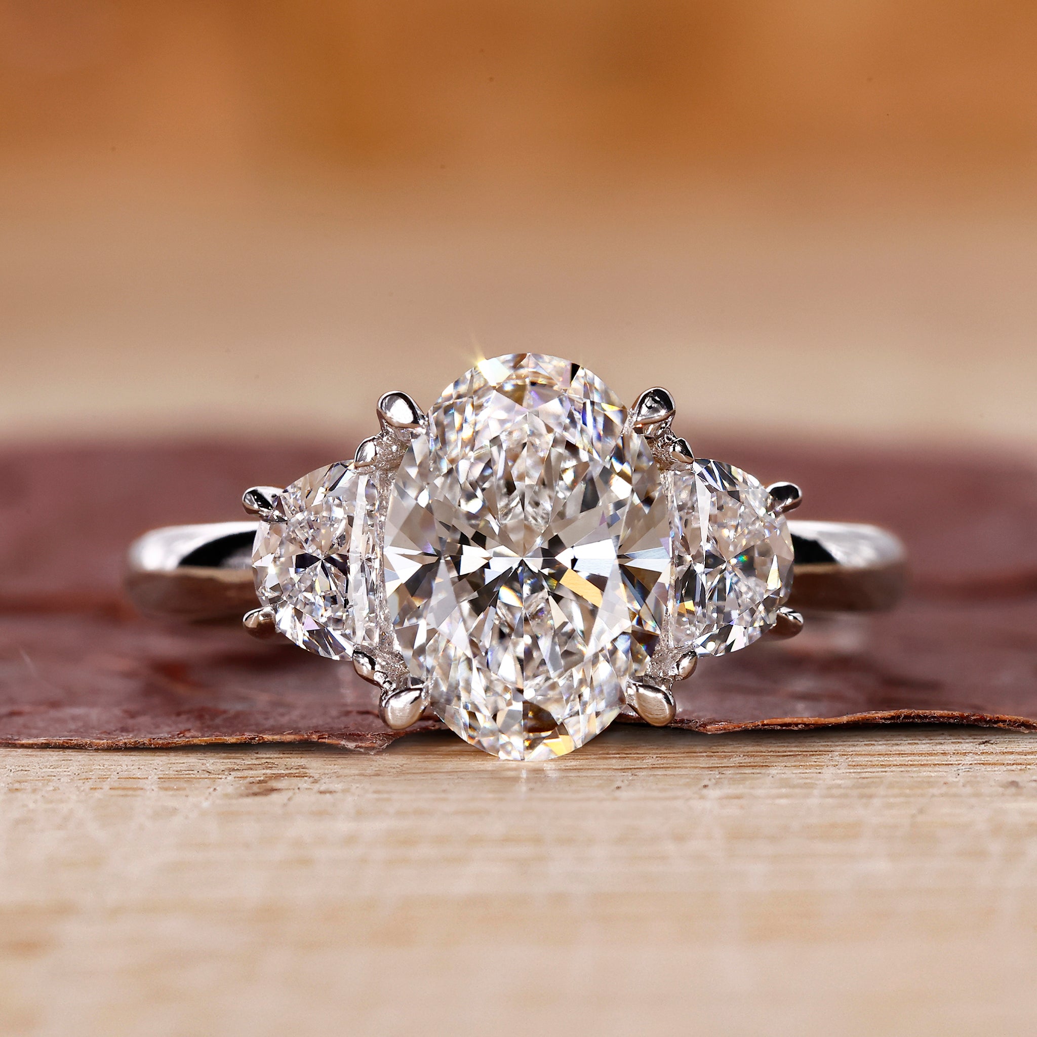 3 stone oval engagement ring with half moon side stones.
